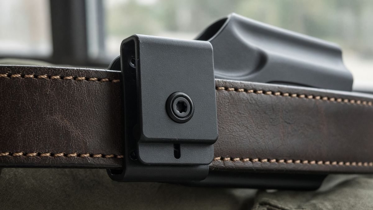 The clip and the retention screw are the holster. A catalog hero gun is not a fit guarantee.